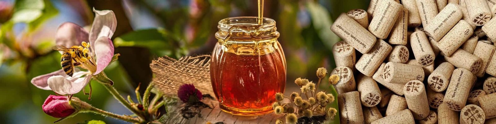 From left to right: A flower & bee, a jar of honey, bottle corks that say 'save the bees drink mead.